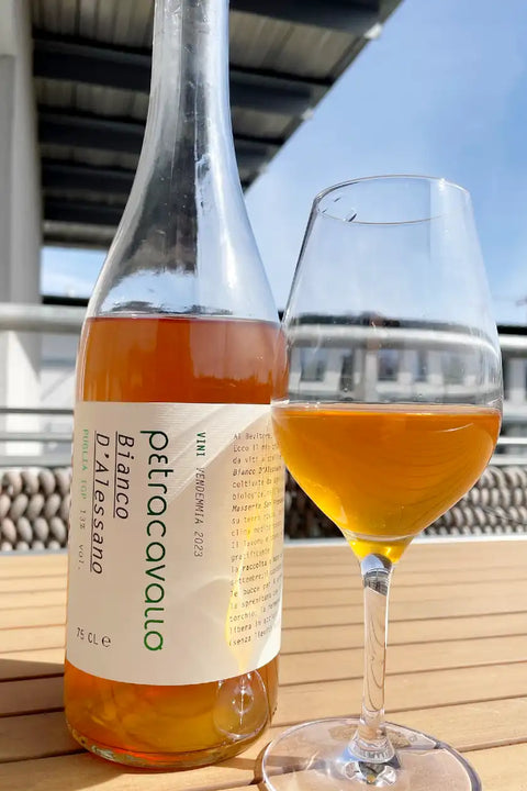 Bottle and glass of Petracavallo Bianco d'Alessano 2023- Natural Wine Dealers