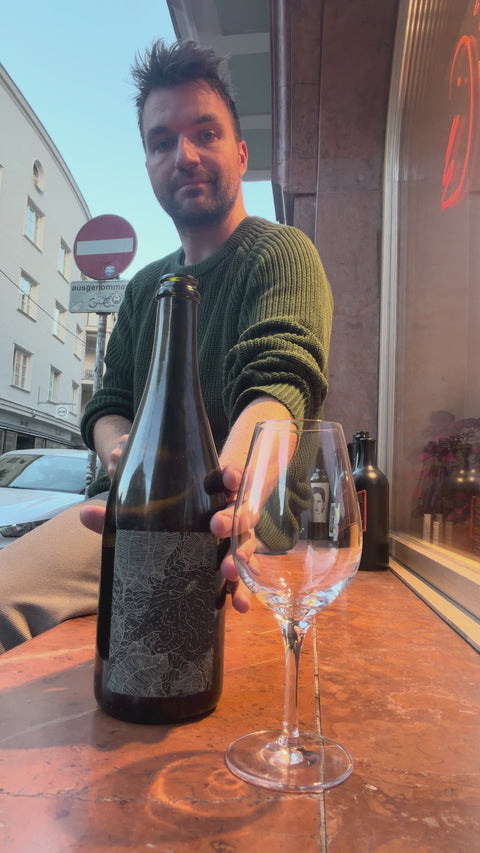 The owner of natural wine dealers is pouring a nice glass of the naboso opera I . its foaming.