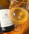 Bottle and glass of Hager Matthias Gemischter Satz 2021 - Natural Wine Dealers