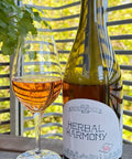 Bottle and glass of Herbal Harmony non-alcoholic beverage with a white label - Natural Wine Dealers