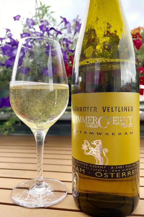 Bottle and a glass of Wimmer Czerny Frühroter Veltliner Fels am Wagram 2024 - Natural Wine Dealers