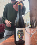 The owner of natural wine dealers is opening the bottle of naboso norma and pouring one glass