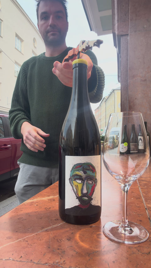 The owner of natural wine dealers is opening the bottle of naboso norma and pouring one glass