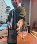 The owner of natural wine dealers is pouring a nice glass of the naboso opera I . its foaming.